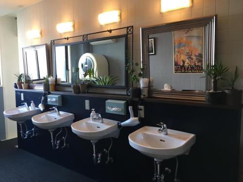 a bathroom with three sinks and a mirror at DJANGO Hostel & Lounge in Tanabe
