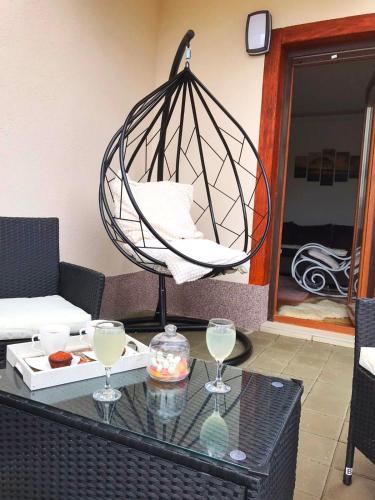 a hanging chair on a table with two wine glasses at Nirvana 06 in Zlatibor