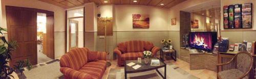 a living room with two couches and a tv at Hotel Wurms in Düsseldorf