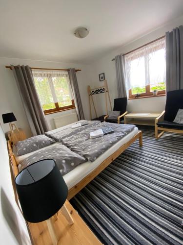 a bedroom with a bed and chairs in it at Pension Ferda in Český Krumlov
