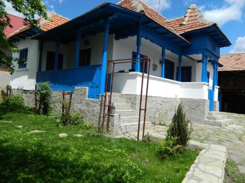 a blue and white house with a stone wall at Casa de vacanta traditionala romaneasca in Schiuleşti