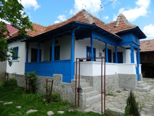 a blue and white house with a red roof at Casa de vacanta traditionala romaneasca in Schiuleşti