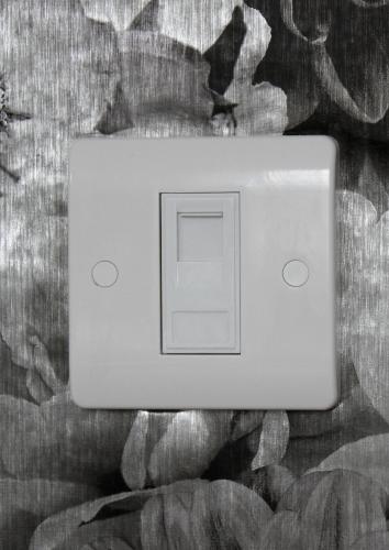 a white light switch sitting on top of a bed at Le Potier Jovial in Ger