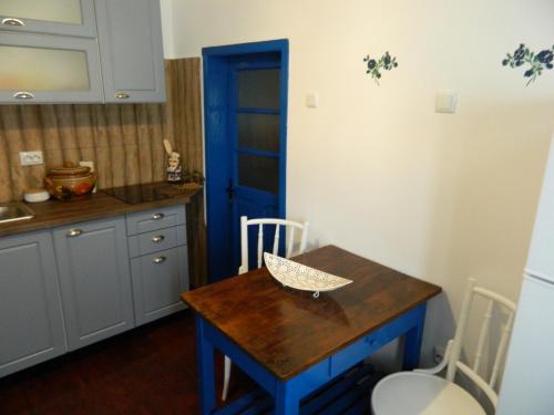 a kitchen with a wooden table and a blue door at Casa de vacanta traditionala romaneasca in Schiuleşti