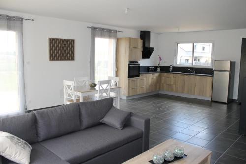 un salon avec un canapé et une cuisine dans l'établissement La Goulette du Vary, à Commes