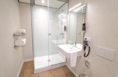 ein Bad mit einem Waschbecken und einer Dusche in der Unterkunft The Fallon Hotel Alkmaar in Alkmaar