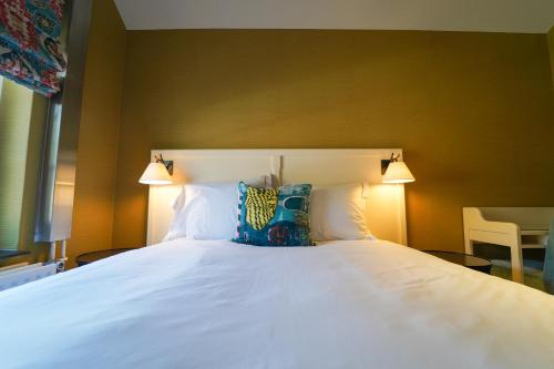a bedroom with a white bed with two lamps at Fletcher Hotel-Restaurant De Oude Gevangenis-Alkmaar in Alkmaar
