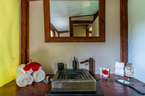 a bathroom with a sink and a mirror on a table at Vaihu Nui Bungalow-Glamping in Hanga Roa