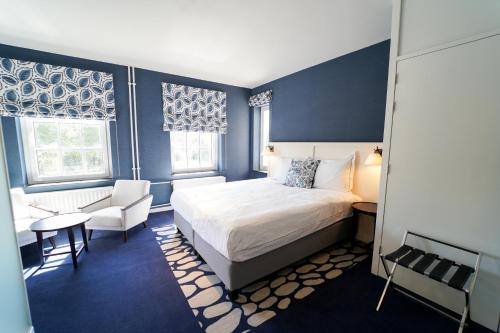 a bedroom with a bed and a chair and a table at Fletcher Hotel-Restaurant De Oude Gevangenis-Alkmaar in Alkmaar