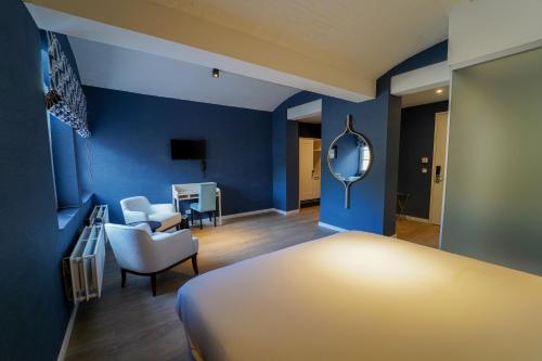 a living room with a bed, chair and a television at The Fallon Hotel Alkmaar in Alkmaar