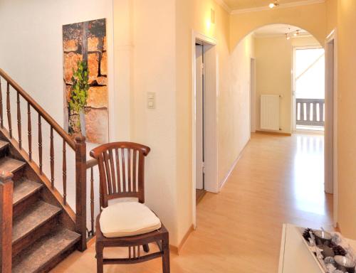 a hallway with a chair and stairs in a house at Fewo Steck in Bruttig-Fankel