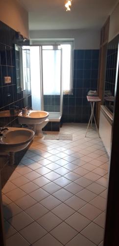 a bathroom with two sinks and a tiled floor at U Agnieszki in Krynica Zdrój