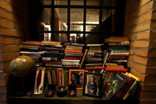 a pile of books sitting on a shelf next to a window at Vila Terrasse in Košice
