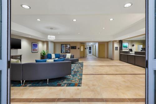 a lobby of a hotel with a couch and chairs at Candlewood Suites Louisville - NE Downtown Area by IHG in Louisville