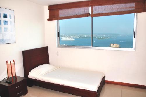 卡塔赫纳帕尔梅托卡塔赫纳Nª3401公寓的一间卧室，里面有一张床和一扇大窗户。