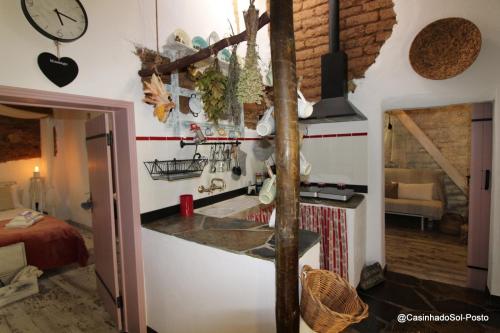 a kitchen with a counter and a clock on the wall at Casinha do Sol-Posto in Monsaraz