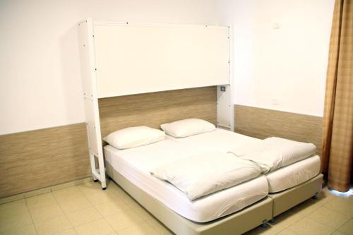 a bed with a bunk bed frame in a room at HI - Massada Hostel in Ein Bokek