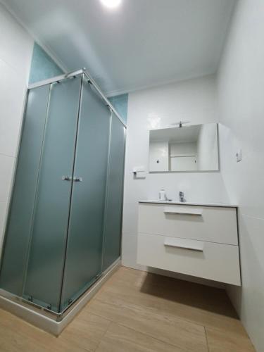 Un baño con ducha de cristal y lavabo. en London - LA COLINA, en San Miguel de Meruelo