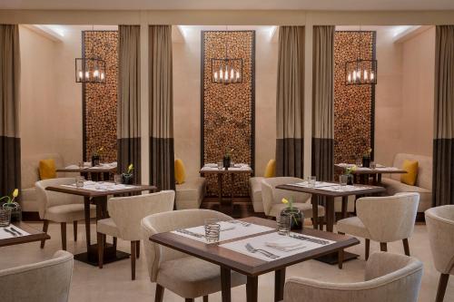 a restaurant with tables and chairs in a room at voco Al Khobar by IHG in Al Khobar