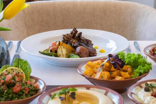 a table with plates of food on a table at voco Al Khobar by IHG in Al Khobar