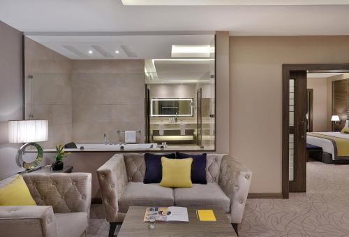 a living room with a couch and a bedroom at voco Al Khobar by IHG in Al Khobar
