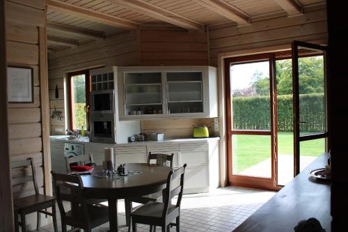 a kitchen and dining room with a table and a window at Dom wakacyjny z basenem in Dębki