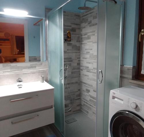 a bathroom with a shower and a washing machine at La Suite attico metro' Volta in Brescia