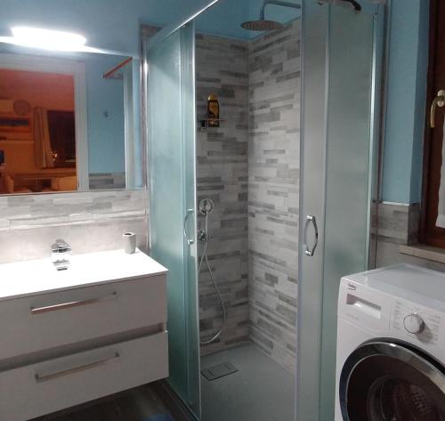 uma casa de banho com um chuveiro e uma máquina de lavar roupa em La Suite attico metro' Volta em Brescia