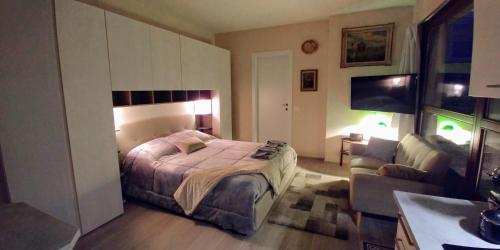 a bedroom with a bed and a couch at La Suite attico metro' Volta in Brescia