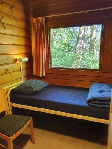 a bedroom with a window in a log cabin at Vakantieoord De Bronzen Emmer in Meppen