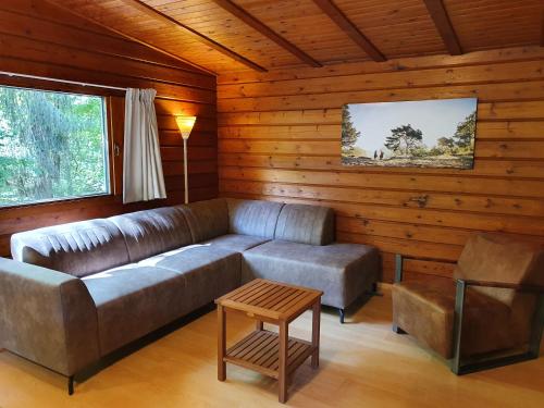 a living room with a couch and a table at Vakantieoord De Bronzen Emmer in Meppen