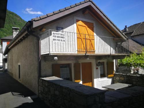 a building with a balcony with a sign on it at Rustico Il Pardo in Maggia