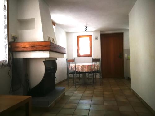 a living room with a fireplace and a table with chairs at Rustico Il Pardo in Maggia