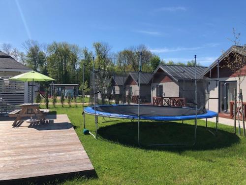 a playground with a trampoline in a yard at Domki Wśród Jabłoni in Gąski