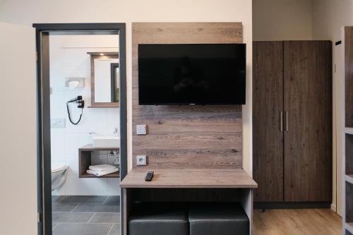 Zimmer mit einem TV an der Wand in der Unterkunft Beisenbusch Hotel & Restaurant in Bottrop