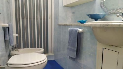een badkamer met een wit toilet en een wastafel bij Casa Vacanza Marco in La Maddalena