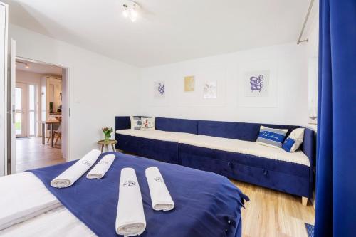 a room with two beds and a blue couch at Apartament 4B Blue Marine Poddąbie in Poddąbie