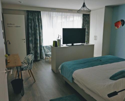 een slaapkamer met een bed en een flatscreen-tv bij B & B De Veurnse Slaper in Veurne