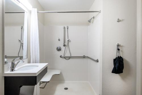 y baño blanco con lavabo y ducha. en Candlewood Suites Lake Mary, an IHG Hotel, en Lake Mary