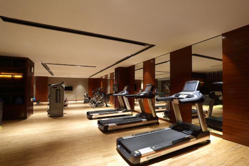 a gym with several treadmills and elliptical machines at HUALUXE Yangjiang City Center in Yangjiang
