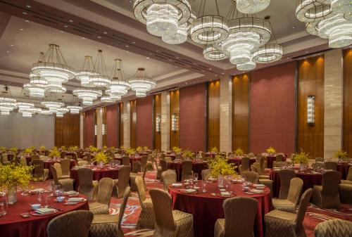 a banquet hall with tables and chairs and chandeliers at HUALUXE Yangjiang City Center in Yangjiang