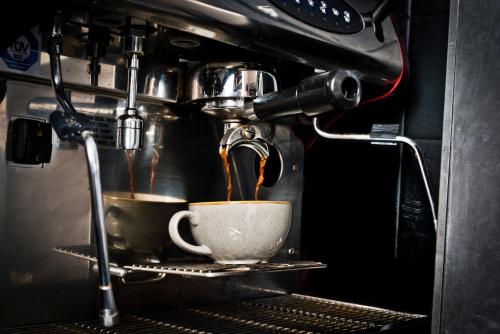 a coffee maker is making a cup of coffee at voco Oxford Spires by IHG in Oxford