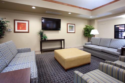 Candlewood Suites Craig-Northwest, an IHG Hotel في كريج: غرفة انتظار مع كنب وتلفزيون بشاشة مسطحة