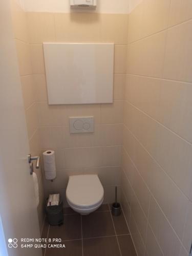 a small bathroom with a toilet and a mirror at Apartment Zama in Štrbské Pleso