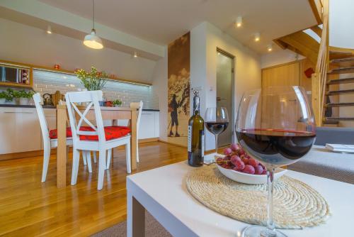 une table avec un verre de vin et un bol de raisin dans l'établissement Apartamenty ROZETA - ZAKOPANE, à Zakopane