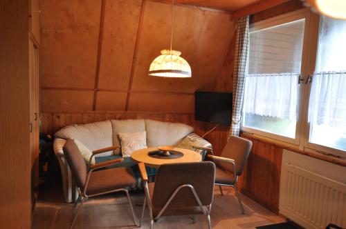 - un salon avec un canapé et une table dans l'établissement Finnhütten Waldesruh, à Lochow