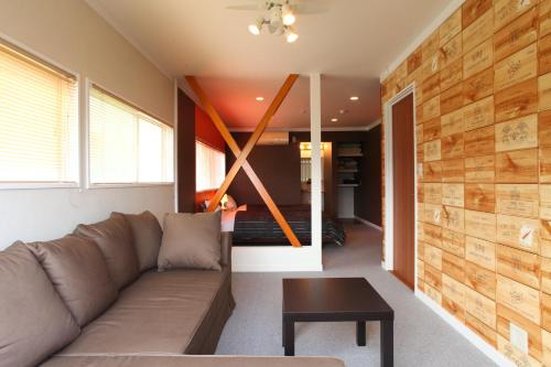 a living room with a couch and a table at Beach Commune Simploose (Adult Only) in Ito