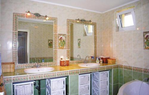 ein Badezimmer mit zwei Waschbecken und zwei Spiegeln in der Unterkunft Pelso Vendégház in Balatonberény