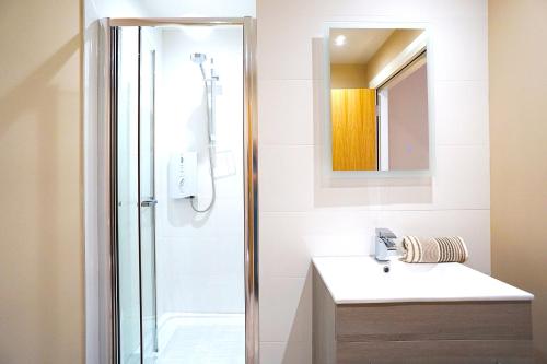 a bathroom with a shower and a sink and a mirror at Bannview Bed & Breakfast in Portadown