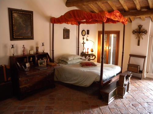 um quarto com uma cama de dossel num quarto em Cesare Magli & Figli Residenza D'Epoca Luxury Rooms em Molinella